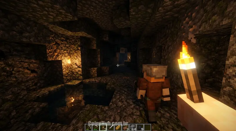 Visão em primeira pessoa dentro de uma caverna no Minecraft com shaders ativos, mostrando iluminação dinâmica de uma tocha, superfícies refletivas e texturas aprimoradas.